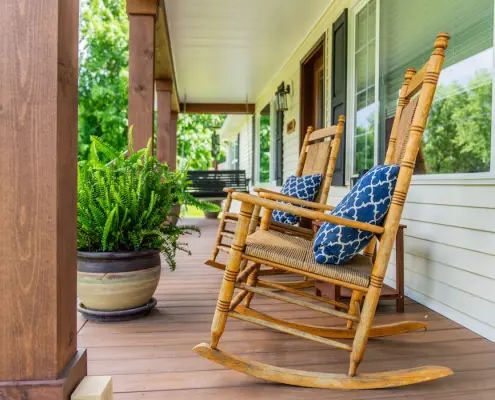 2024-05_Heartland_CindyCountsPorch_27 Two rocking chairs with blue pillows next to each other on a porch in Grottoes, VA.