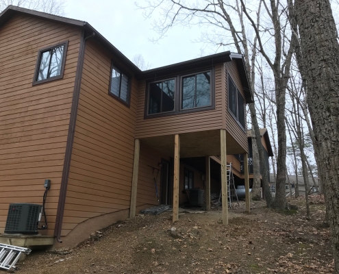 wood siding home with sunroom on stilts