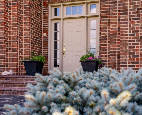 An exterior photo of a front door with windows around it.