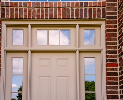 An exterior photo of a front door with windows around it.