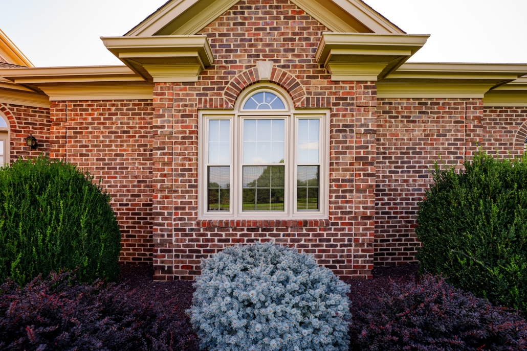 Exterior view of replacement windows on a brick home.