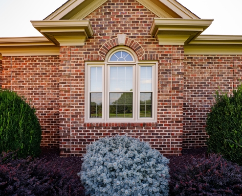 Exterior view of replacement windows on a brick home.