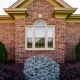 Exterior view of replacement windows on a brick home.